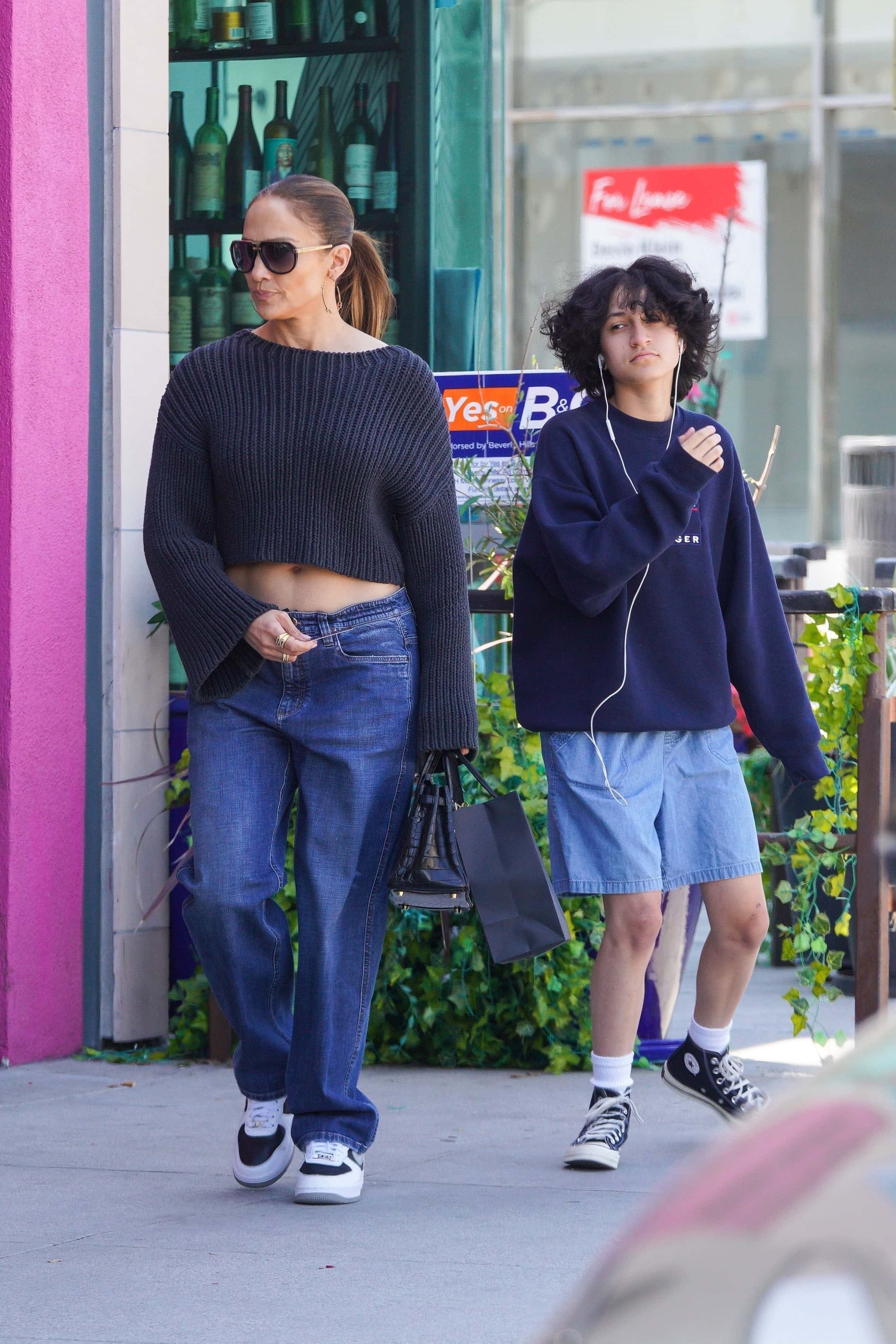 Casual yet chic: Emme - who Jennifer previously referred to using they/them pronouns - donned a similarly comfortable yet chic ensemble featuring a navy blue sweatshirt and denim shorts (Backgrid)