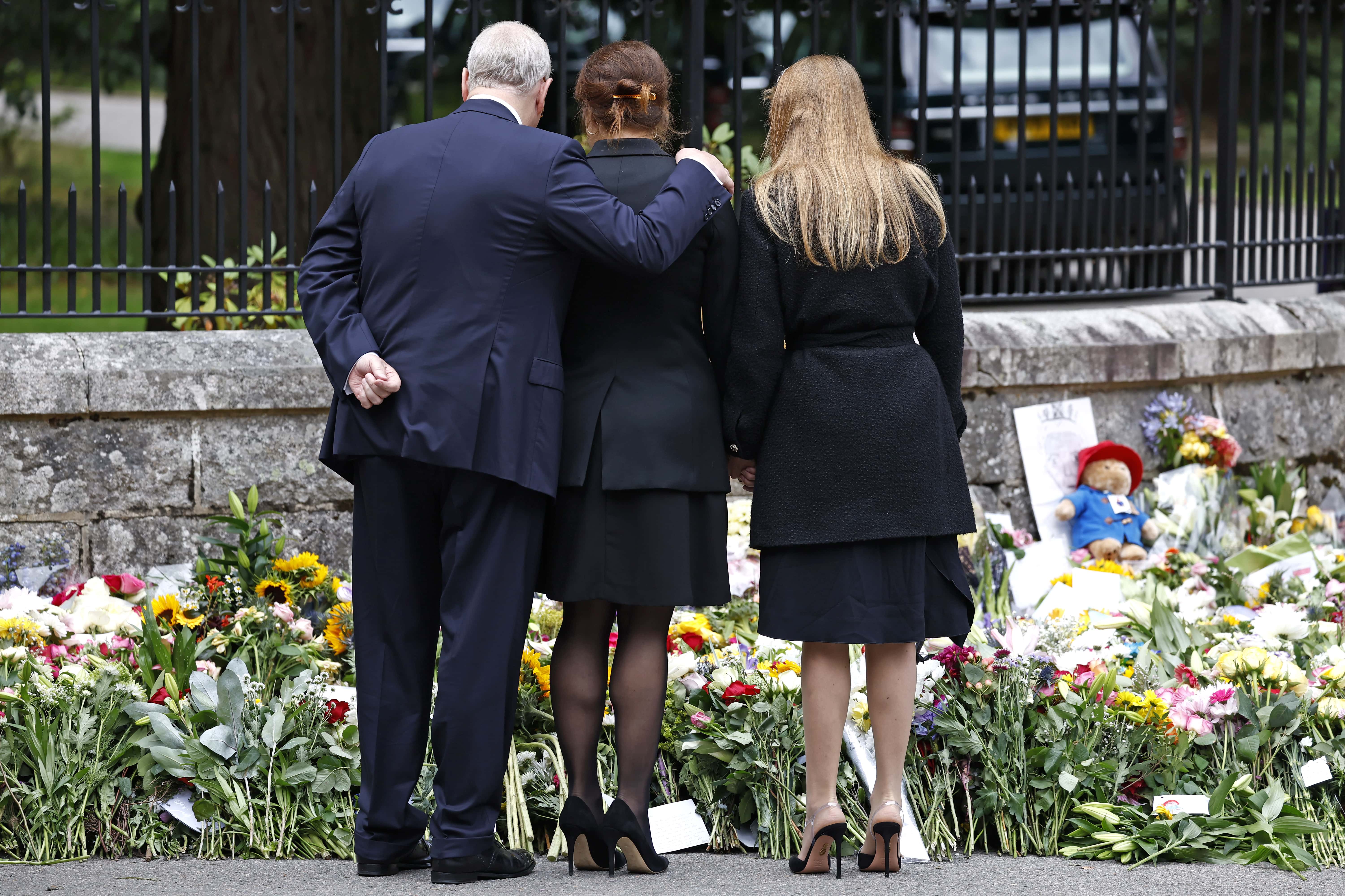 Prince Andrew, Duke of York puts his arm around Princess Eugenie of York and Princess Beatrice of York as they look at floral tributes outside Crathie Kirk church on September 10, 2022 in Crathie near Aberdeen, United Kingdom. Elizabeth Alexandra Mary Windsor was born in Bruton Street, Mayfair, London on 21 April 1926. She married Prince Philip in 1947 and acceded to the throne of the United Kingdom and Commonwealth on 6 February 1952 after the death of her Father, King George VI. Queen Elizabeth II died at Balmoral Castle in Scotland on September 8, 2022, and is succeeded by her eldest son, King Charles III.