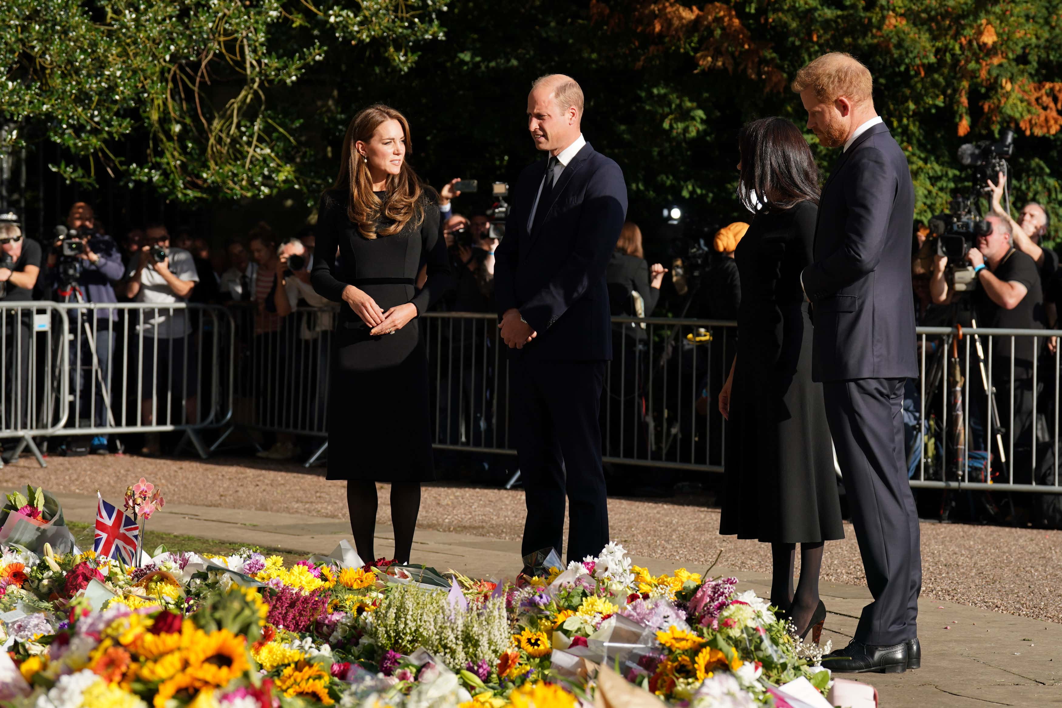 Catherine, Princess of Wales, Prince William, Prince of Wales, Prince Harry, Duke of Sussex, and Meghan, Duchess of Sussex view floral tributes left at Windsor Castle on September 10, 2022 in Windsor, England. Crowds have gathered and tributes left at the gates of Windsor Castle to Queen Elizabeth II, who died at Balmoral Castle on 8 September, 2022.