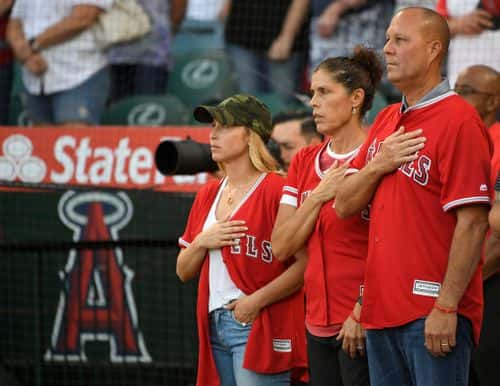 Tyler Skaggs wife Carli Skaggs, his mother Debbie Hetman stand next to step father Danny Hetman during the National Anthem before the Los Angeles Angels of Anaheim play the Seattle Mariners at Angel Stadium of Anaheim on July 12, 2019 in Anaheim, California.