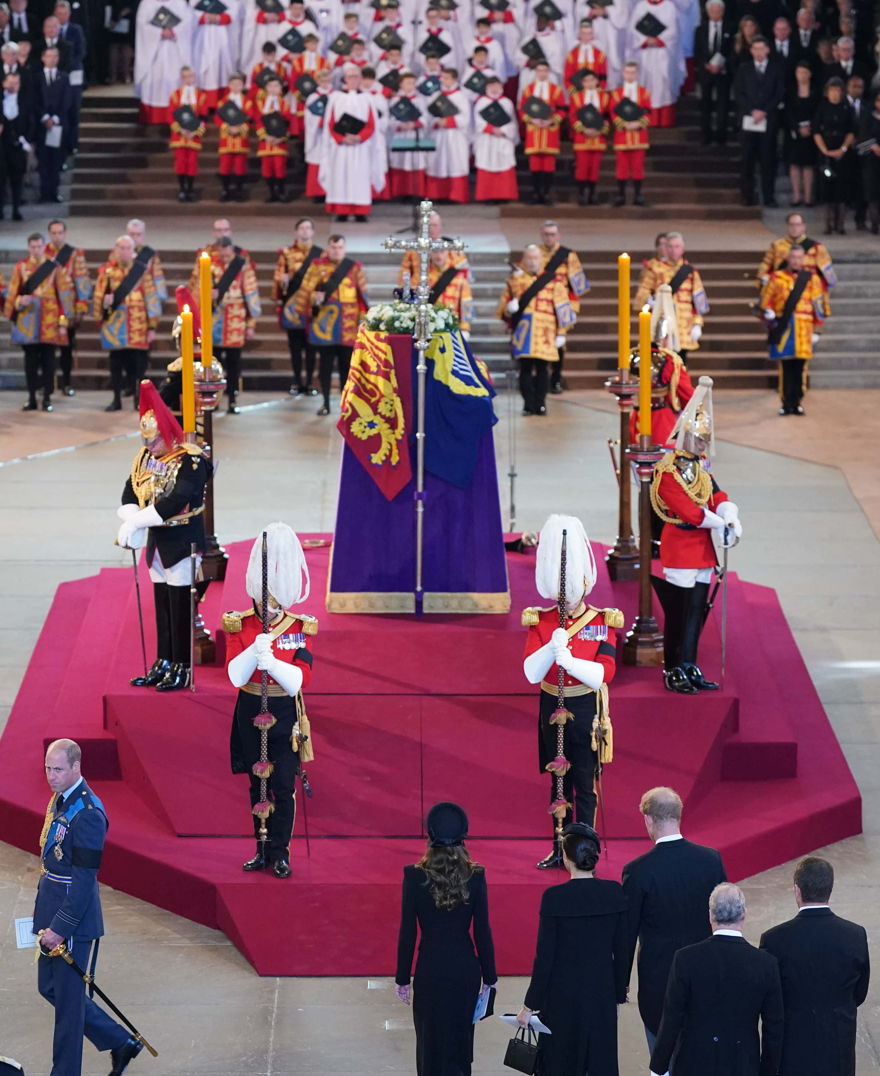 The royal family (bottom, left to right) the Prince of Wales, the Princess of Wales, the Duchess of Sussex, the Prince of Wales, the Earl of Snowdon and Peter Phillips leave as the vigil begins around the coffin of Queen Elizabeth II on the catafalque in Westminster Hall, London, where it will lie in state ahead of her funeral on Monday, on September 14, 2022 in London, England.
