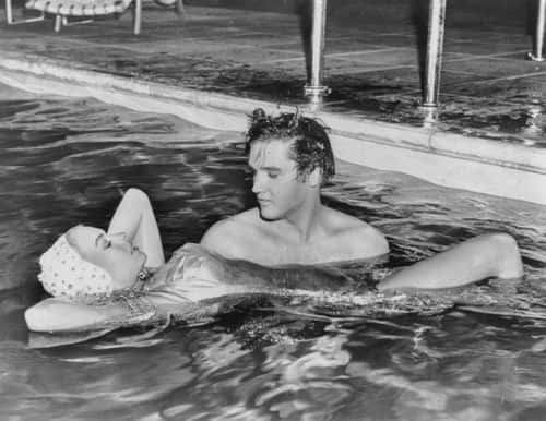Singer Elvis Presley holding up actress Jennifer Holden, his co-star in the film 'Jailhouse Rock', as they spend time together in a swimming pool, circa 1957. (Photo by Keystone/Hulton Archive/Getty Images)