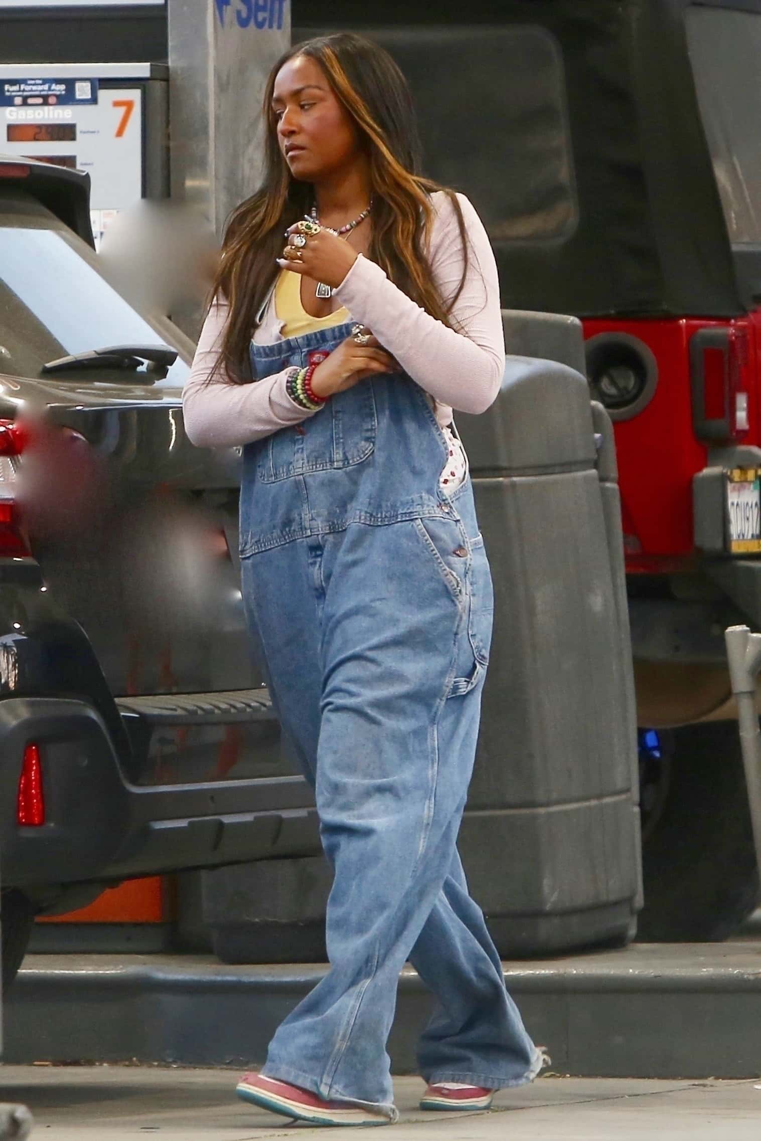 The 21-year-old showed off her cool-girl aesthetic in a long-sleeve cream top layered over a yellow shirt, which she paired with baggy Dickies overalls (Backgrid)