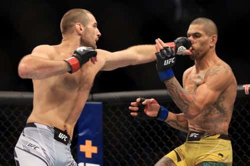 Sean Strickland (L) punches Alex Pereira of Brazil in their middleweight bout during UFC 276 at T-Mobile Arena on July 02, 2022 in Las Vegas, Nevada.
