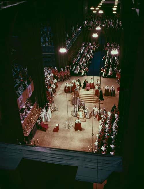 High angle view of the coronation of British Royal Queen Elizabeth II (1926-2022), flanked by British Anglican bishop Michael Ramsey (1904-1988), Bishop of Durham, and British Anglican bishop Geoffrey Fisher (1887-1972), Archbishop of Canterbury, as the Queen's husband, Prince Philip, Duke of Edinburgh (1921-2021), approaches the throne to pay personal homage and swear allegiance to the Queen following the crowning ceremony of the Queen's Coronation, held at Westminster Abbey, London, England, 2nd June 1953. (Photo by Central Press/Hulton Archive/Getty Images)