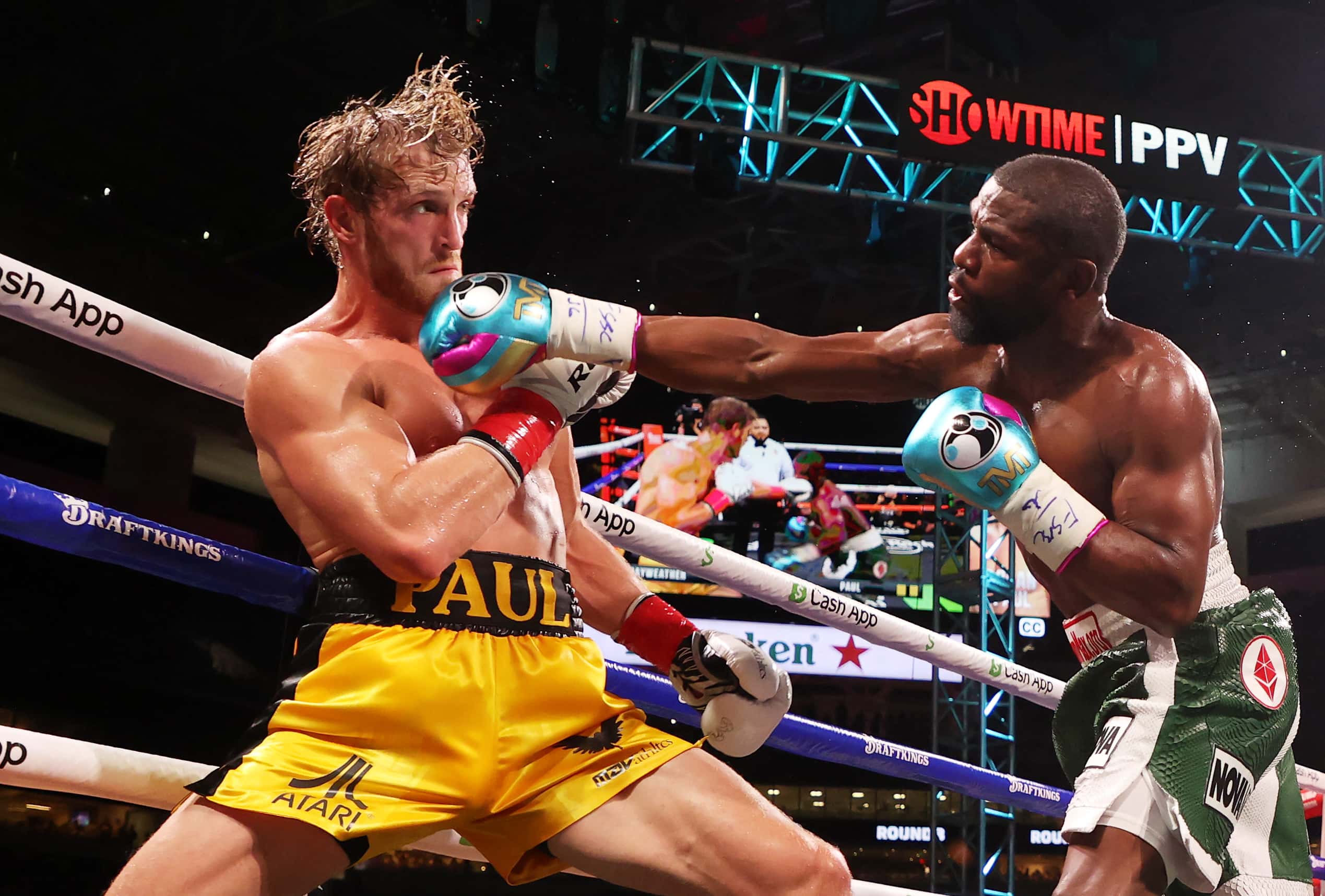 MIAMI GARDENS, FLORIDA - JUNE 06: Floyd Mayweather (R) punches Logan Paul during their contracted ex