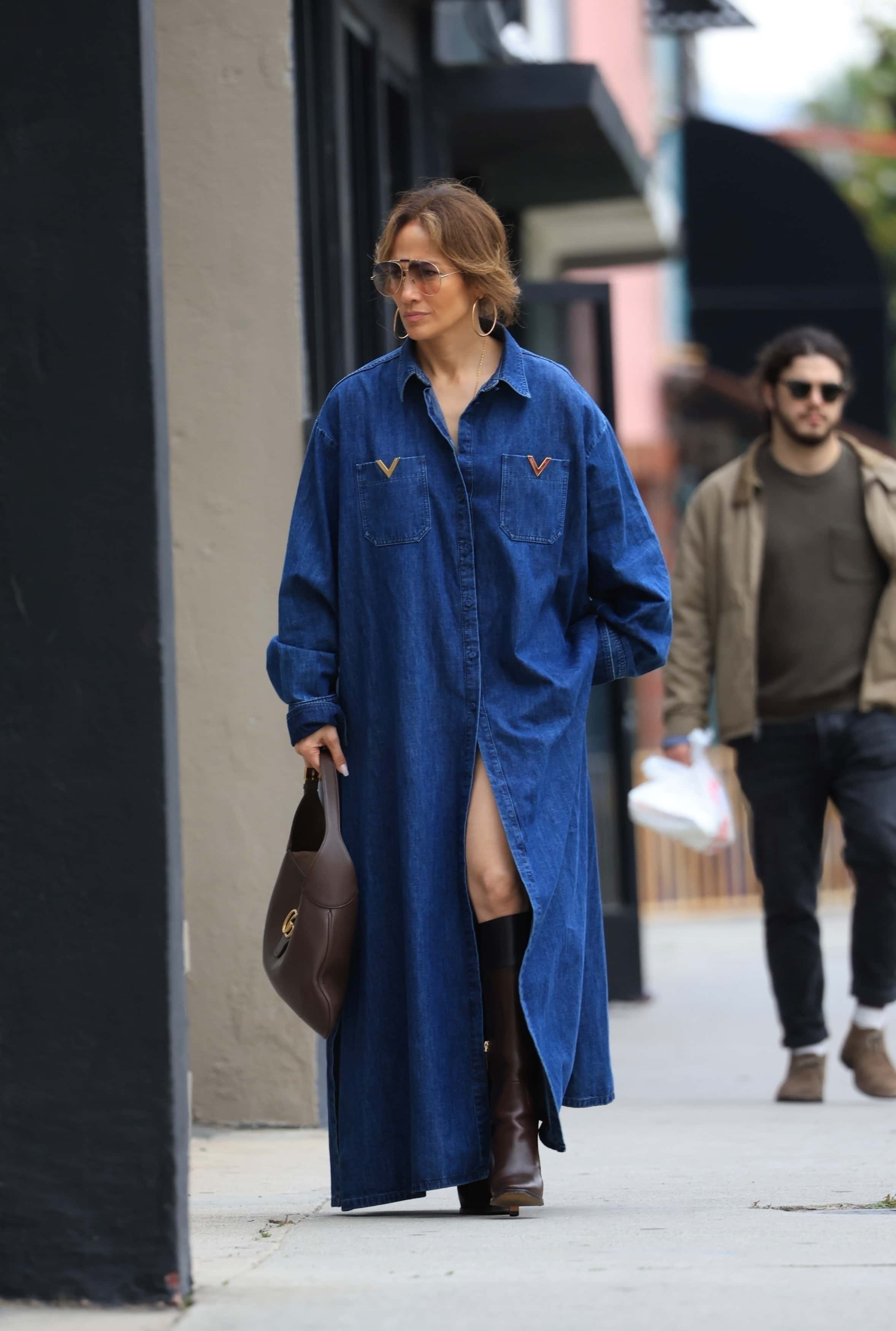 The singer accessorized her look with knee-high black leather boots and a brown Gucci handbag (Backgrid)