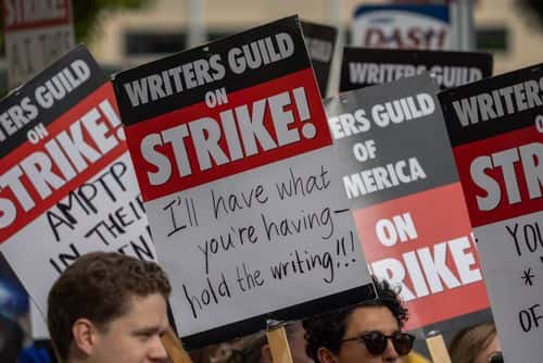 People picket outside of Paramount Pictures studios during the Hollywood writers strike on May 4, 2023 in Los Angeles, California. Scripted TV series, late-night talk shows, film and streaming productions are being interrupted by the Writers Guild of America (WGA) strike. In 2007 and 2008, a WGA strike shut down Hollywood productions for 100 days, costing the local economy between $2 billion and $3 billion.