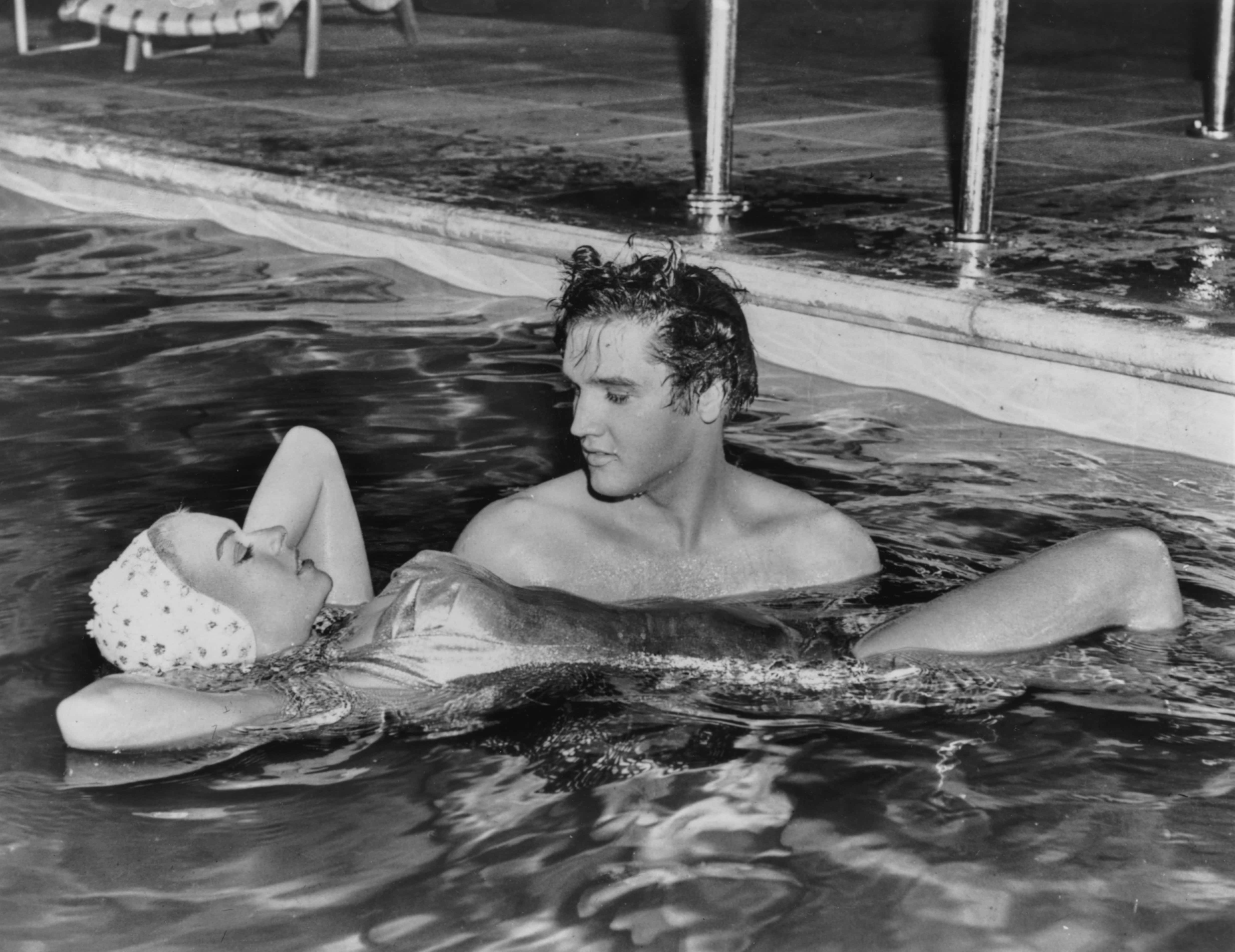 Singer Elvis Presley holding up actress Jennifer Holden, his co-star in the film 'Jailhouse Rock', as they spend time together in a swimming pool, circa 1957. (Photo by Keystone/Hulton Archive/Getty Images)
