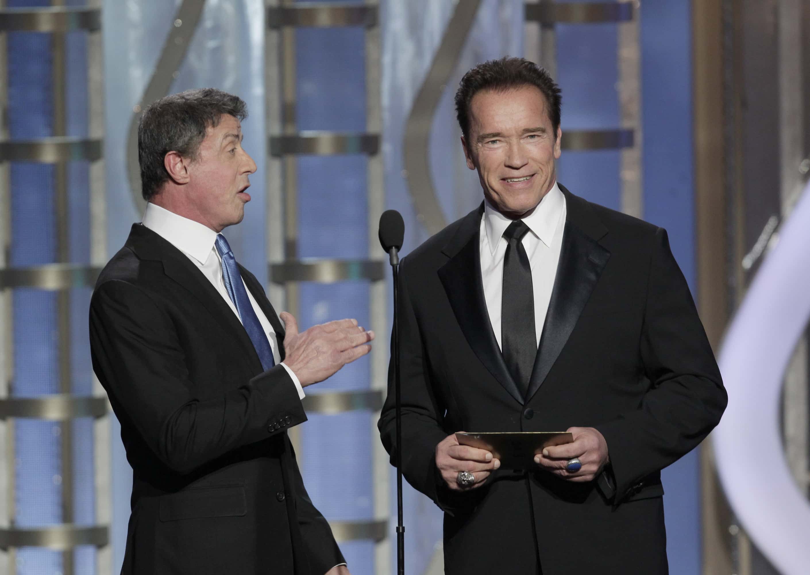 BEVERLY HILLS, CA - JANUARY 13: In this handout photo provided by NBCUniversal, Actors Sylvester Stallone and Arnold Schwarzenegger on stage to present during the 70th Annual Golden Globe Awards at the Beverly Hilton Hotel International Ballroom on January 13, 2013 in Beverly Hills, California. (Photo by Paul Drinkwater/NBCUniversal via Getty Images)
