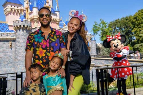 In this handout photo provided by Disneyland Resort, John Legend, Chrissy Teigen and their children, Miles and Luna pose with Minnie Mouse while celebrating Luna’s birthday at Disneyland on April 14, 2022 in Anaheim, California.