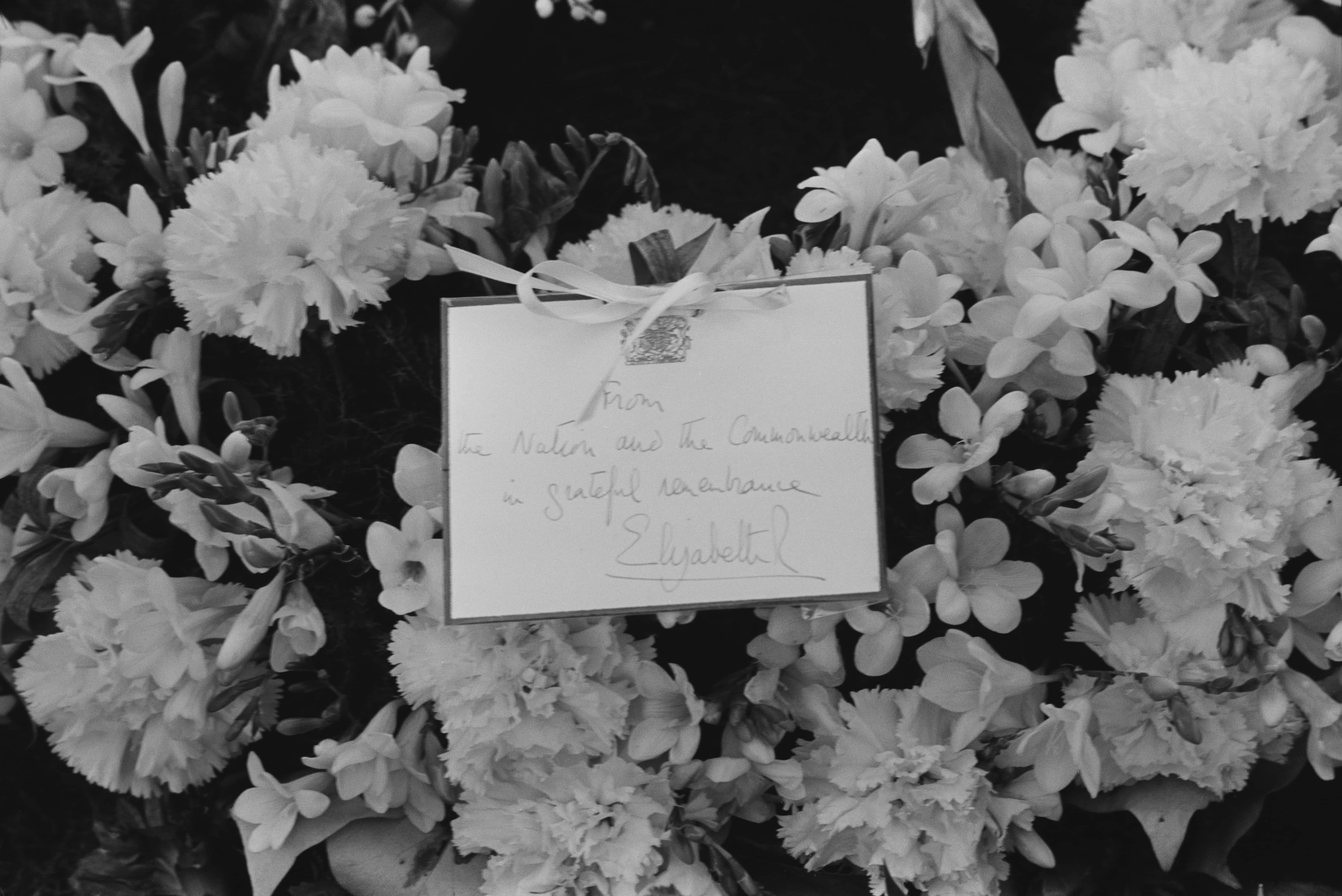 A wreath and note from Queen Elizabeth II on Sir Winston Churchill's grave in Bladon, Oxfordshire, 31st January 1965. It reads 'From the nation and the Commonwealth in grateful remembrance, Elizabeth R'. (Photo by McCabe/Express/Hulton Archive/Getty Images)
