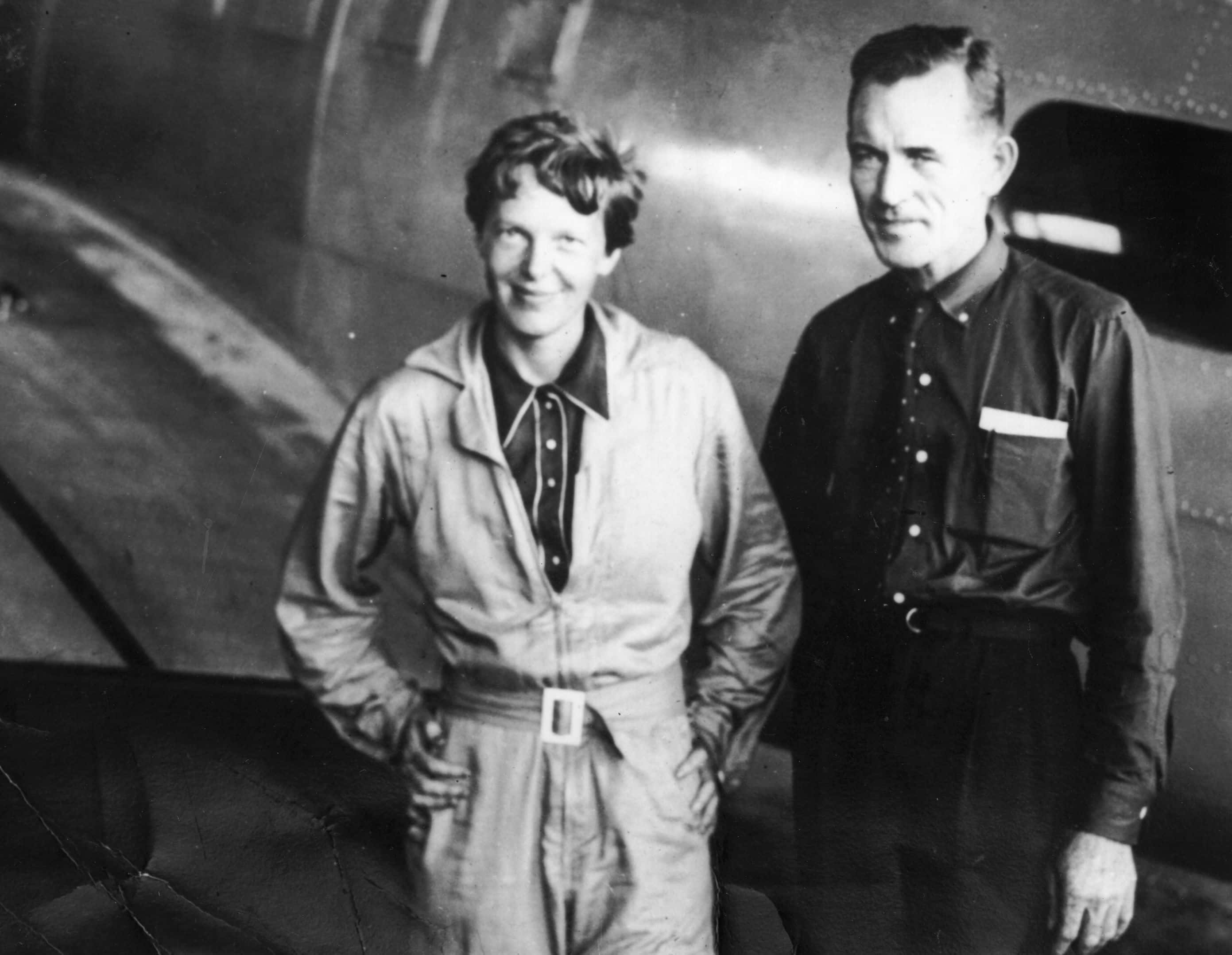 : American aviatrix Amelia Earhart (1897 - 1937) with her navigator, Captain Fred Noonan, in the hangar at Parnamerim airfield, Natal, Brazil, 11th June 1937 (Getty Images)
