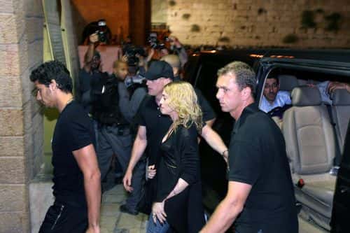 (ISRAEL OUT) US pop music star Madonna (C), escorted by her security guards, and her Brazilian boyfriend Jesus Luz (L), enter the Western Wall tunnel, part of Judaism's holiest site, on August 30, 2009 in Jerusalem's Old City. Madonna landed in Israel early morning ahead of two scheduled Tel Aviv concerts, the final stop on her 'Sticky and Sweet' tour. The Western Wall is seen in the background on the right.