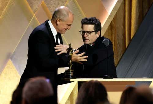 (L-R) Woody Harrelson presents Michael J. Fox with the Jean Hersholt Humanitarian Award onstage during the Academy of Motion Picture Arts and Sciences 13th Governors Awards at Fairmont Century Plaza on November 19, 2022 in Los Angeles, California. (Photo by Kevin Winter/Getty Images)