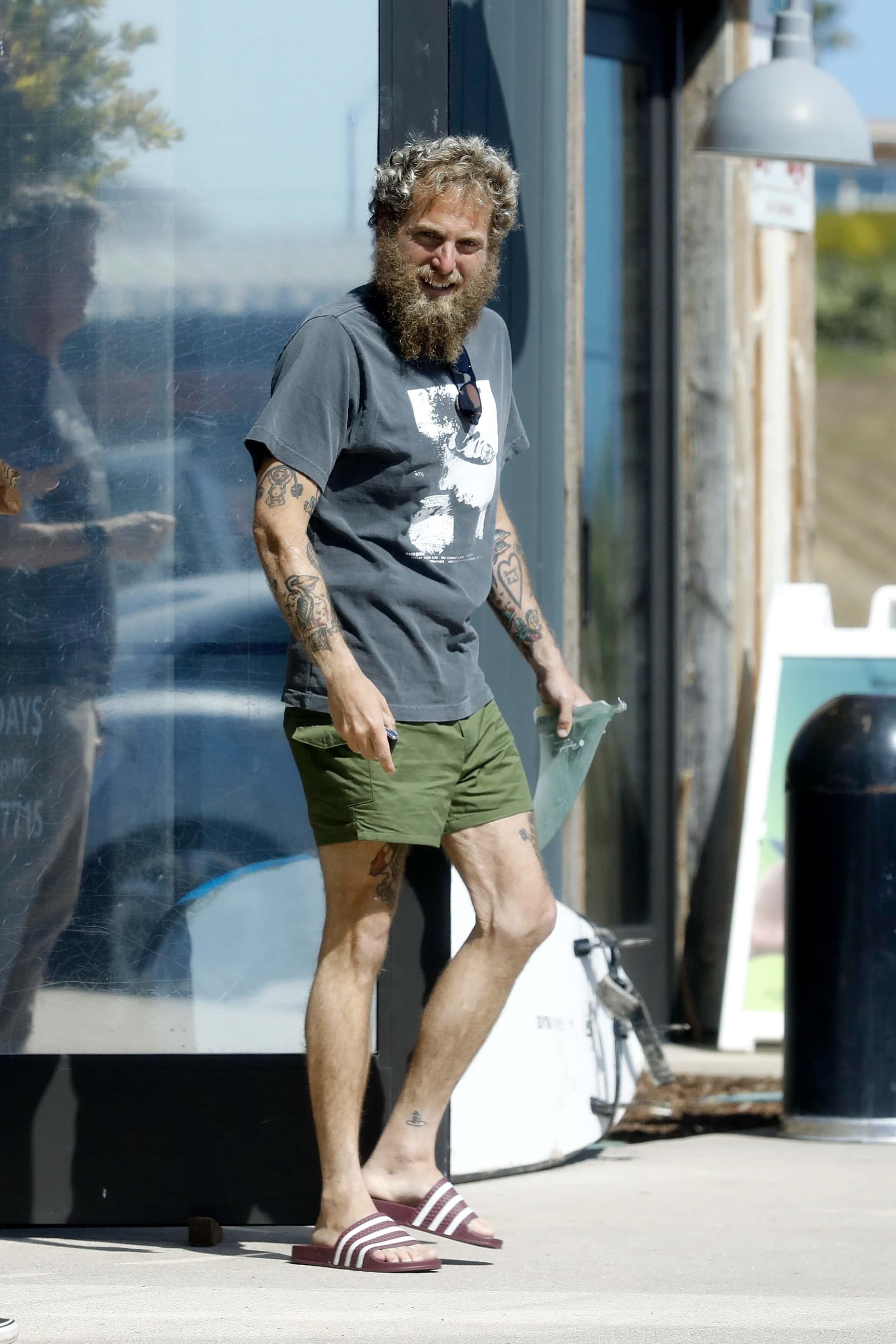 Jonah showed off the intricate tattoos on his legs, and a charcoal slogan t-shirt which did the same for his toned arms (Backgrid)

