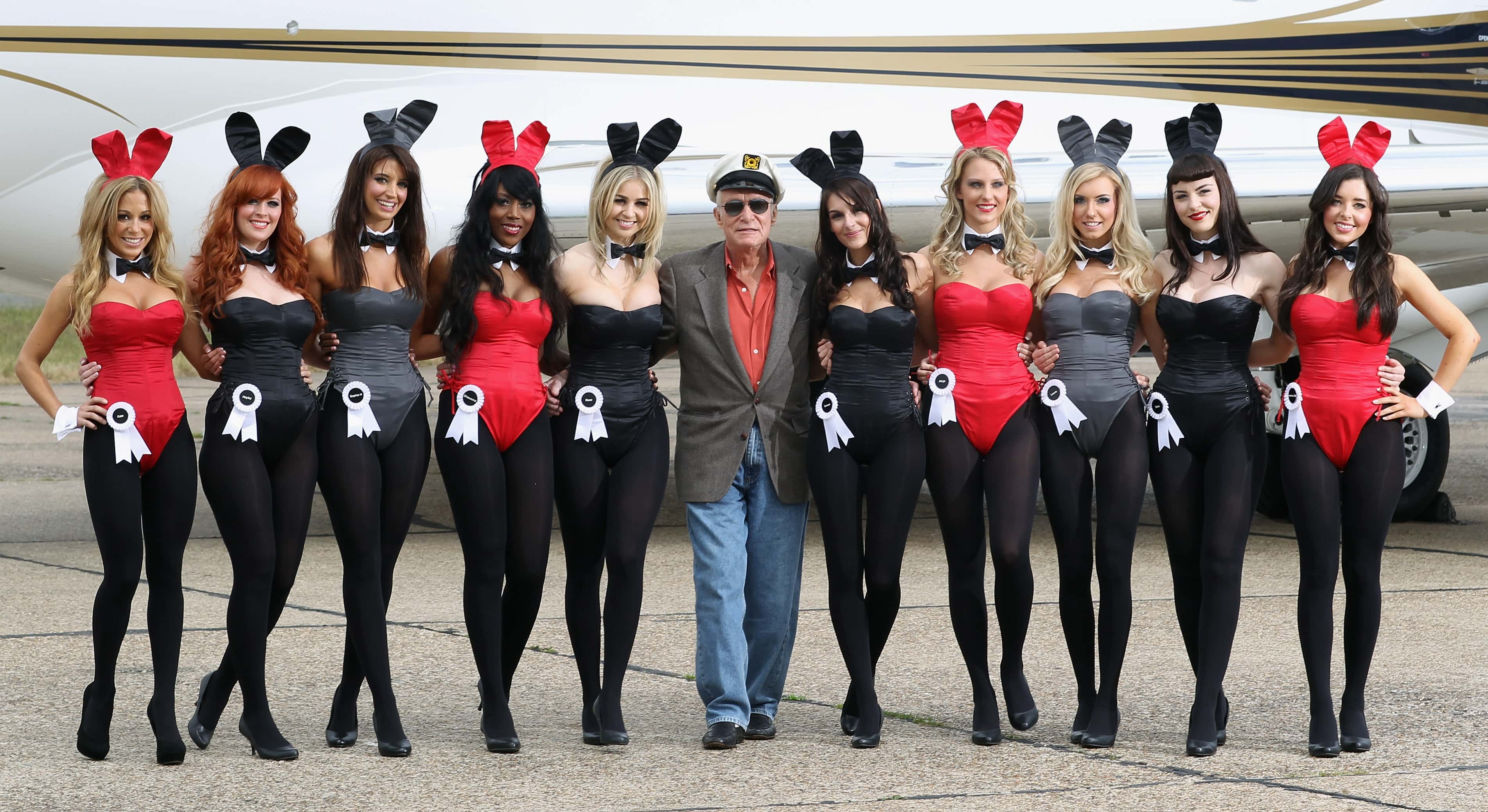 Playboy founder Hugh Hefner (centre) arrives at Stansted Airport on June 2, 2011 in Stansted, England. The photograph is a recreation of a picture originally taken in the 1960's, with ten of the new London Bunnies. Mr Hefner is back in the UK to mark the launch of the new Playboy Club in Mayfair, which opens on June 4. The clubs opening will welcome back the iconic Playboy Bunny to Londonafter a 30 year absence. Famous Bunnies have included Debbie Harry and Lauren Hutton.