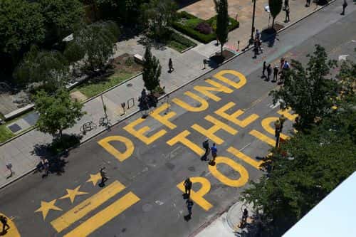 People walk down 16th street after “Defund The Police” was painted on the street near the White House on June 08, 2020 in Washington, DC. After days of protests in DC over the death of George Floyd, DC Mayor Muriel Bowser has renamed that section of 16th street