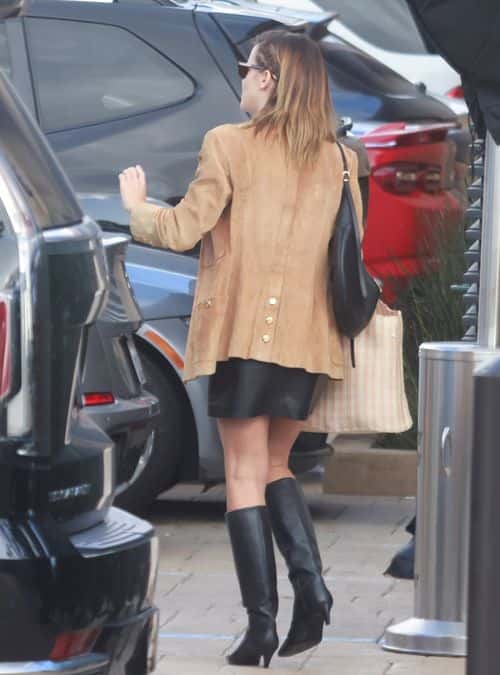 Emma was carrying a black purse with gold straps and a light pink and white striped tote bag (Backgrid)