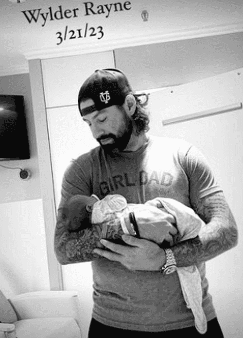 Thompson also shared a snap of him holding his daughter, wearing a grey 'Girl Dad' t-shirt and a black baseball cap (Instagram/@nathanthompson)