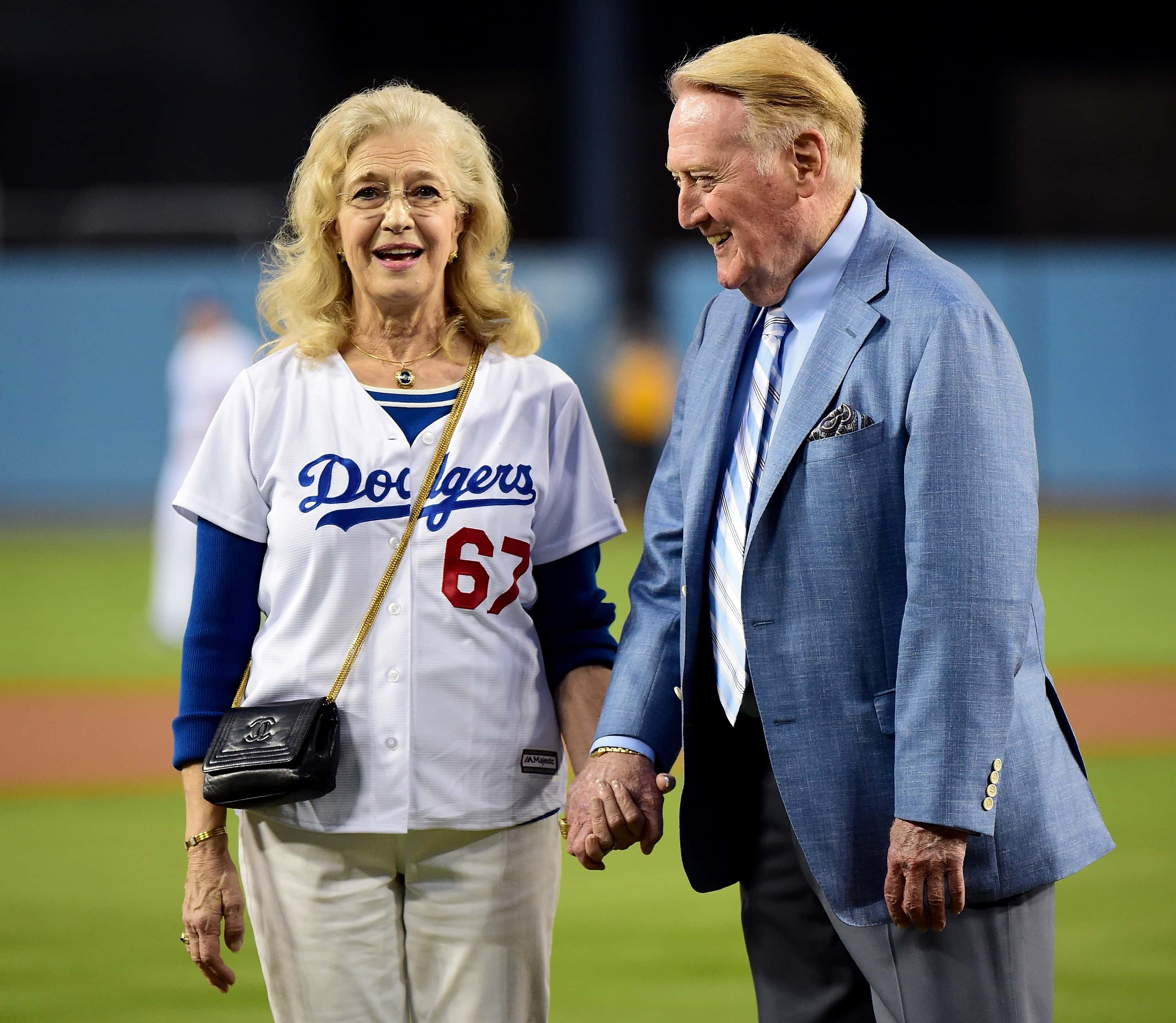 Los Angeles Dodgers broadcaster Vin Scully and wife Sandi Scully hold hands on the field before the game against the Arizona Diamondbacks at Dodger Stadium on September 23, 2015 in Los Angeles, California.