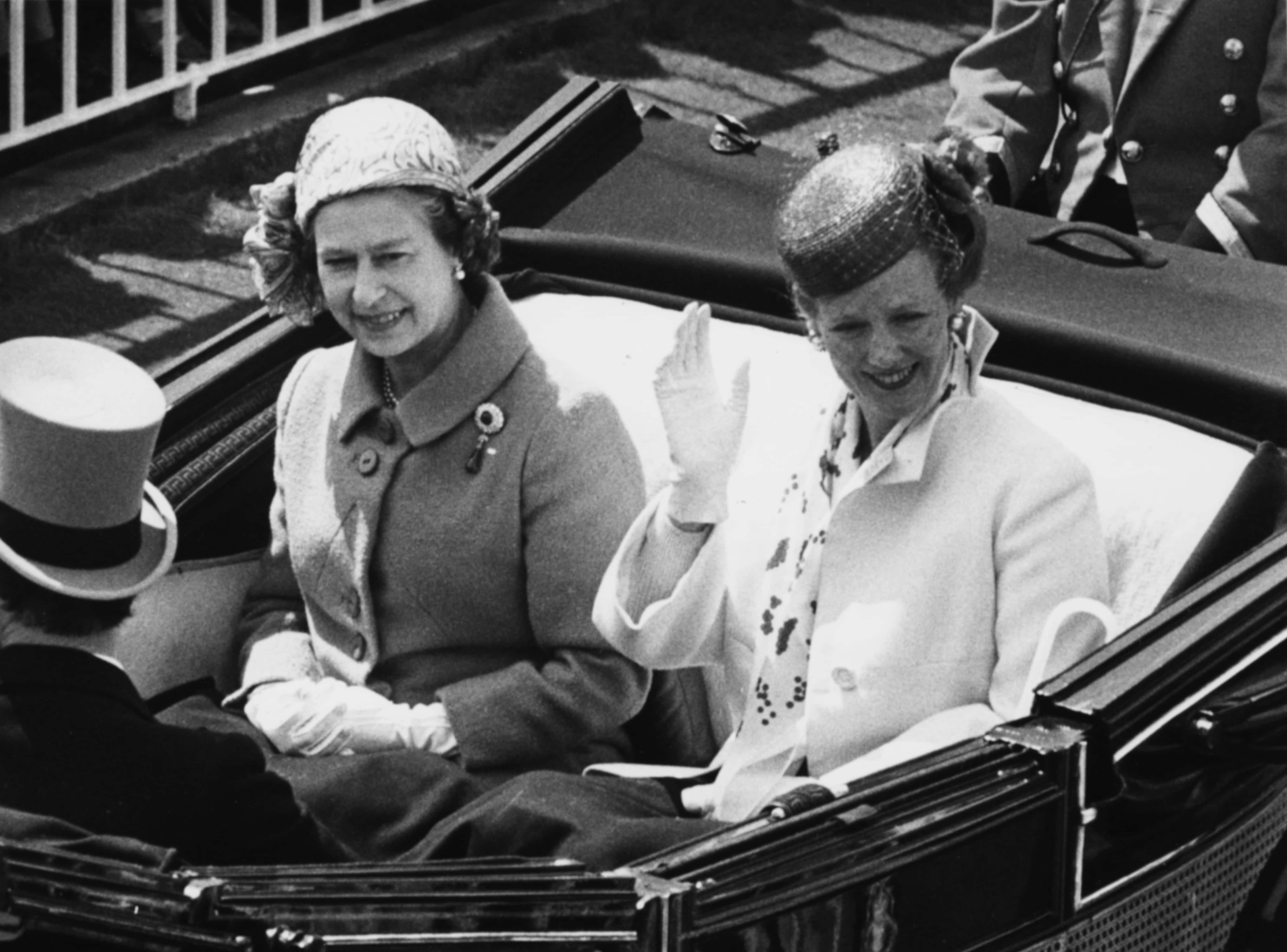 Queen Margrethe of Denmark (right) waving as she rides in an open carriage with Queen Elizabeth II , on their way to Royal Ascot, England, June 17th 1980. (Photo by Dennis Oulds/Central Press/Getty Images)