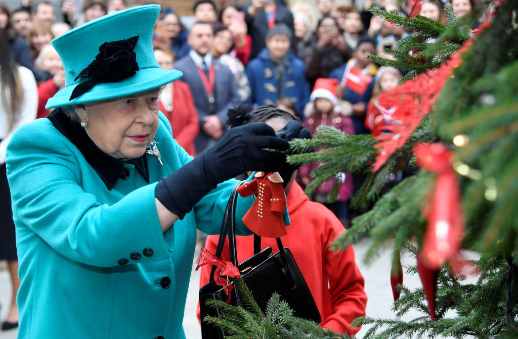 Queen Elizabeth II and Shylah Gordon, aged 8, attach a bauble to a Christmas tree during the opening of the Queen Elizabeth II centre at CORAM on December 05, 2018, in London, England. (Getty Images)