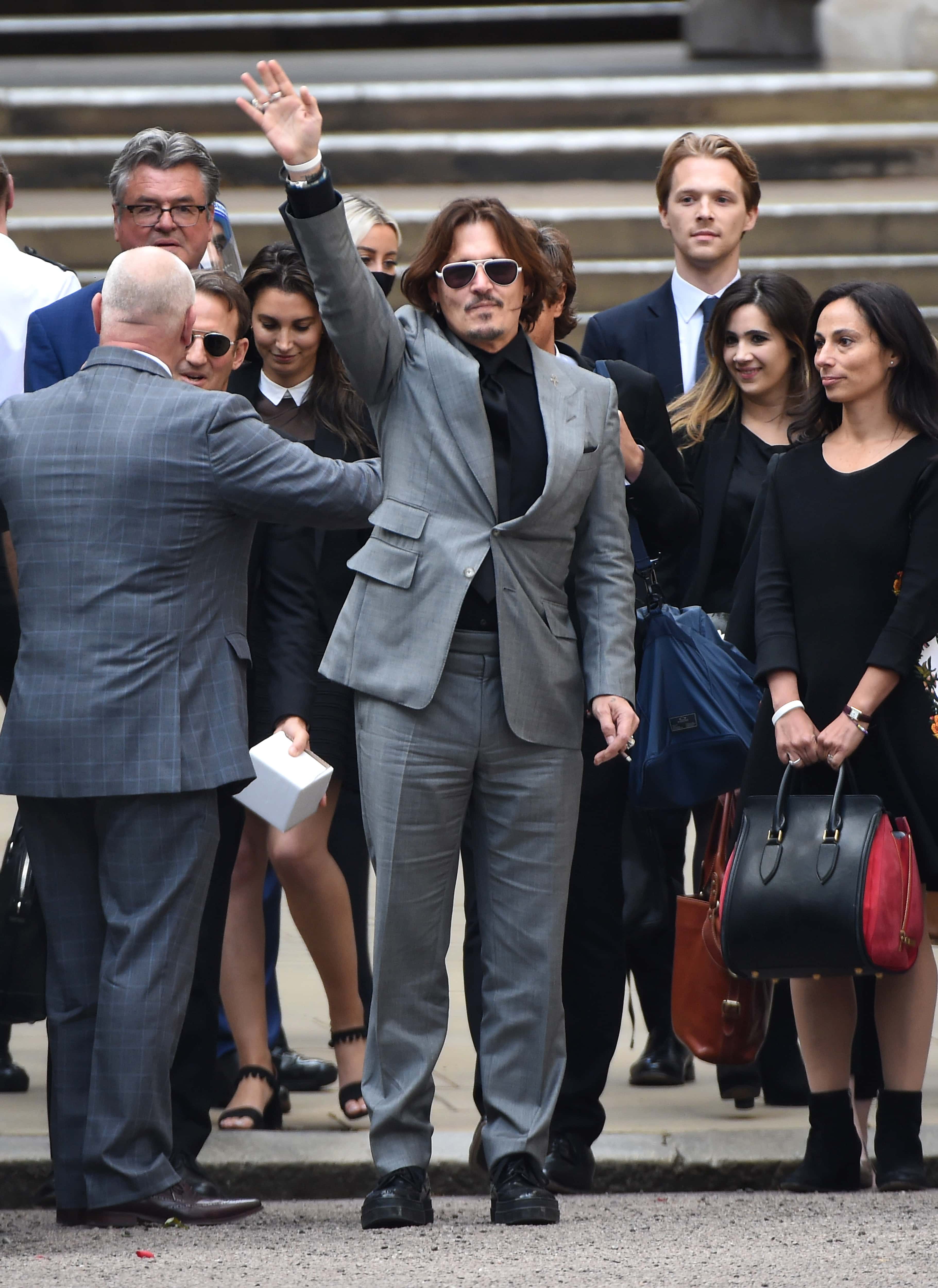 Johnny Depp waves as he departs the Royal Courts of Justice, the Strand on July 28, 2020 in London, England. The Hollywood actor is suing News Group Newspapers (NGN) and the Sun's executive editor, Dan Wootton, over an article published in 2018 that referred to him as a