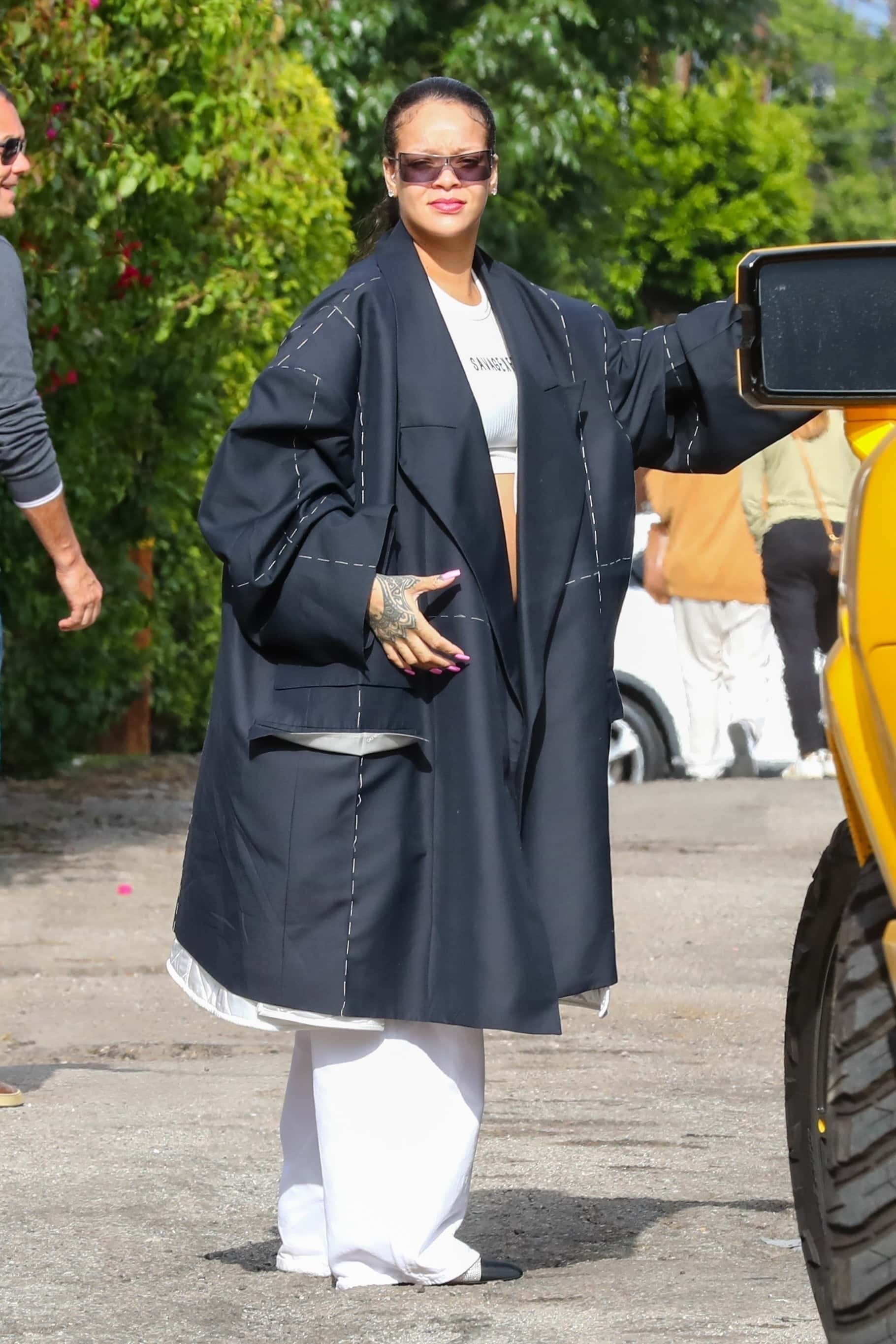 Rihhan opted for a classy maternity style as she bared her bump in a white crop top and an oversized navy blazer (Backgrid)

