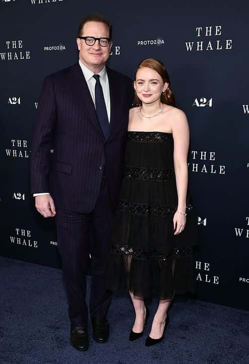 Fraser hit the red carpet in a dark blue suit with red pinstripes, as he also posed next to his on-screen daughter in The Whale, Sadie Sink. (Jamie McCarthy/Getty Images)