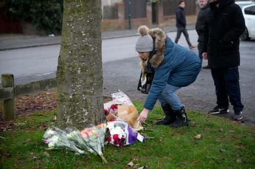 Flowers are left at the scene as emergency workers continue the search for further victims after a number of children fell through ice on a lake, on December 12, 2022 at Babbs Mill Park in Solihull, England. Three boys aged eight, 10 and 11 have died after falling through an icy lake last night. The search continued for more potential victims, following reports more children were present on the ice at the time of the incident.