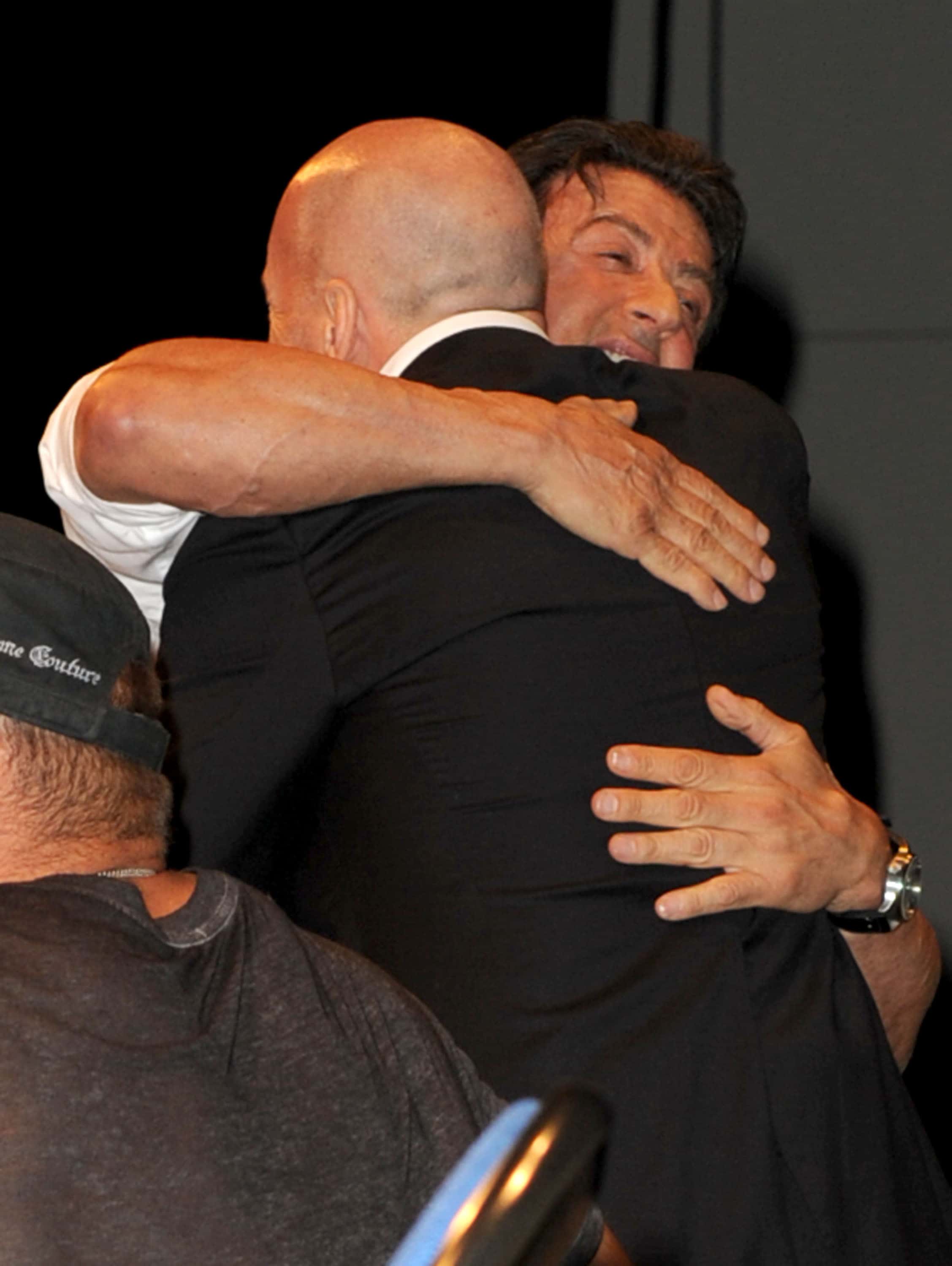 Actor/Director Sylvester Stallone (L) hugs actor Bruce Willis onstage at the 
