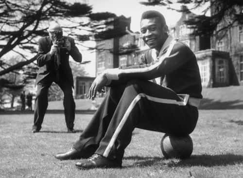 Star of the Brazilian football  team, Pele (Edson Arantes do Nascimento) sits on the ball during a break in training at Selsdon Park Hotel where they are staying. The Brazilians are to play England at Wembley.