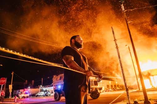 A man looks over caution tape during a second night of rioting on August 24, 2020 in Kenosha, Wisconsin. The civil unrest occurred after the shooting of Jacob Blake, 29, on August 23. Blake was shot multiple times in the back by Wisconsin police officers after attempting to enter into the drivers side of a vehicle.