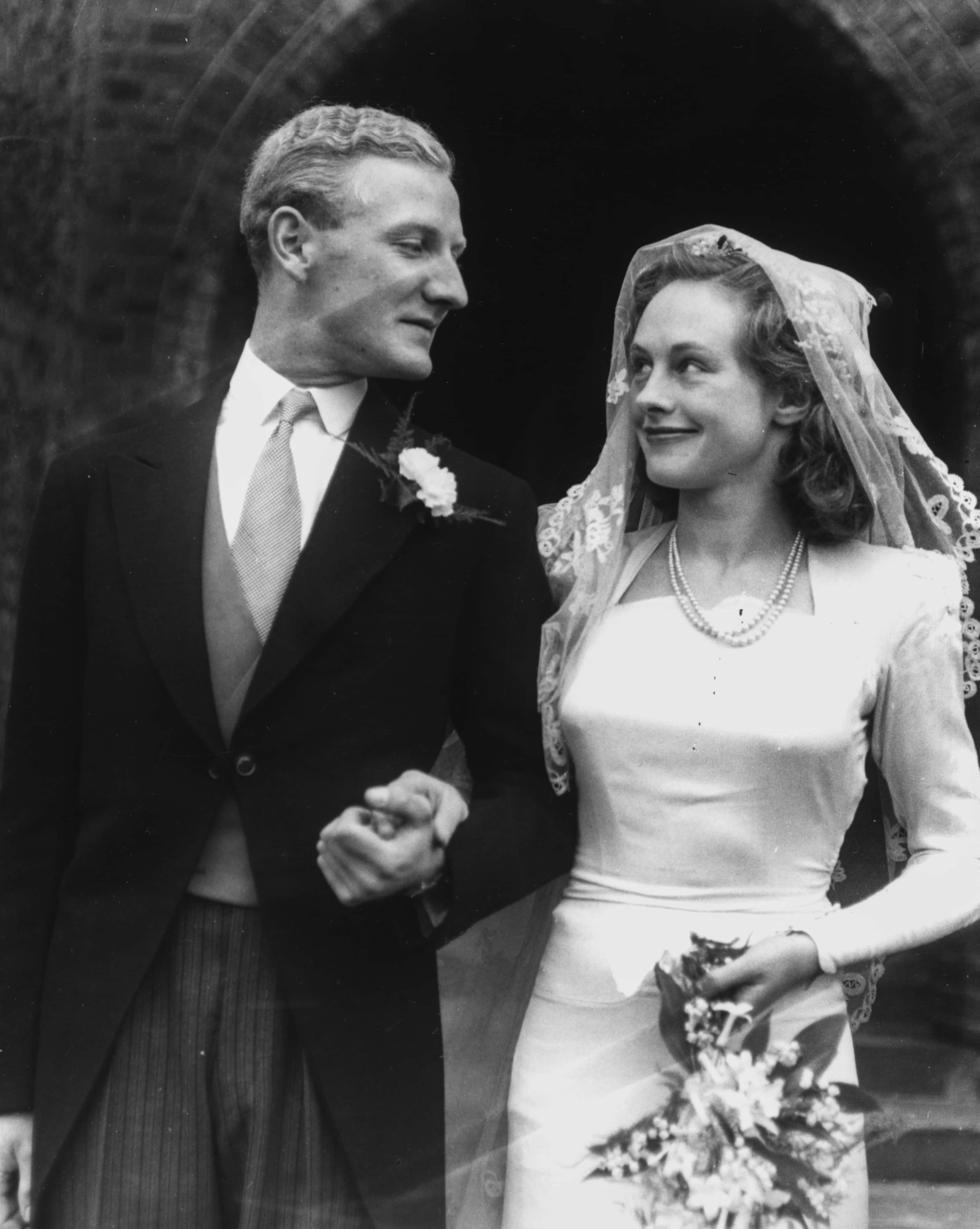 Comic actor Leslie Phillips and his bride Penelope Bartley pictured looking in to each others eyes outside All Soul's Church following their wedding ceremony, St John's Wood, London, May 30th 1948. (Photo by Keystone/Hulton Archive/Getty Images)