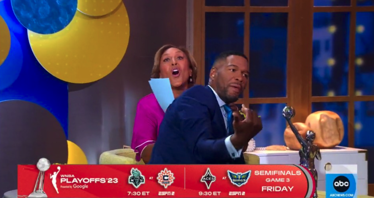 Michael Strahan sat on her co-host Robin Roberts' lap during live-air (ABC)