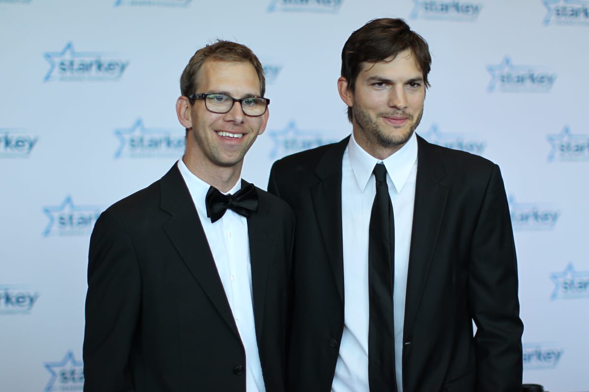 Michael Kutcher and brother Ashton Kutcher walk the red carpet before the 2013 Starkey Hearing Foundation's 
