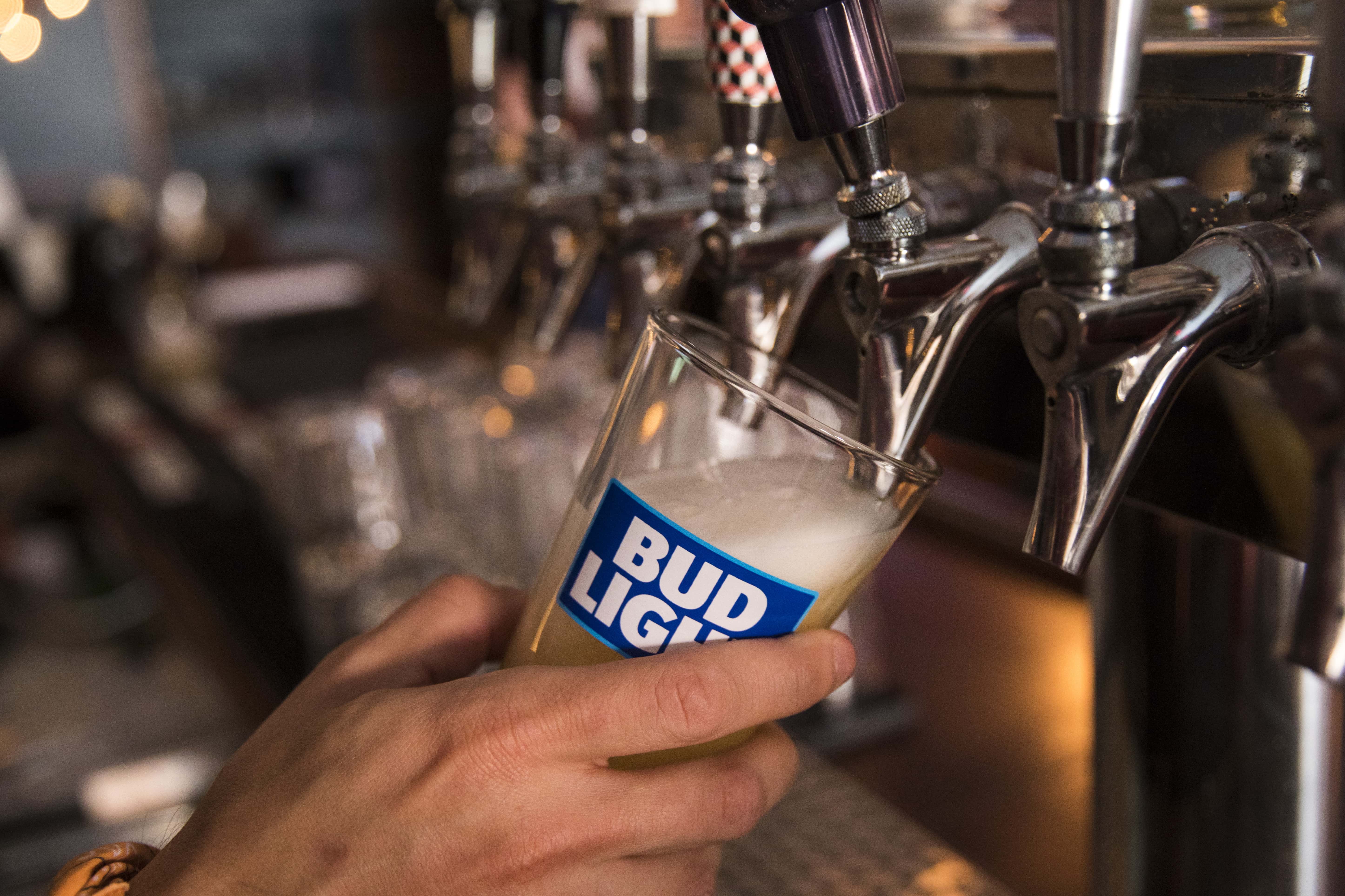 NEW YORK, NY - JULY 26: In this photo illustration, a bartender pours a Bud Light from a tap, July 2