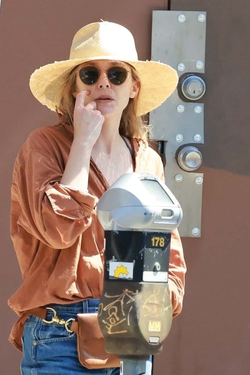 WandaVision star, 34, embraces summer fashion with a straw safari hat, makeup-free face, and Ray-Ban Blaze Round sunglasses (Backgrid)