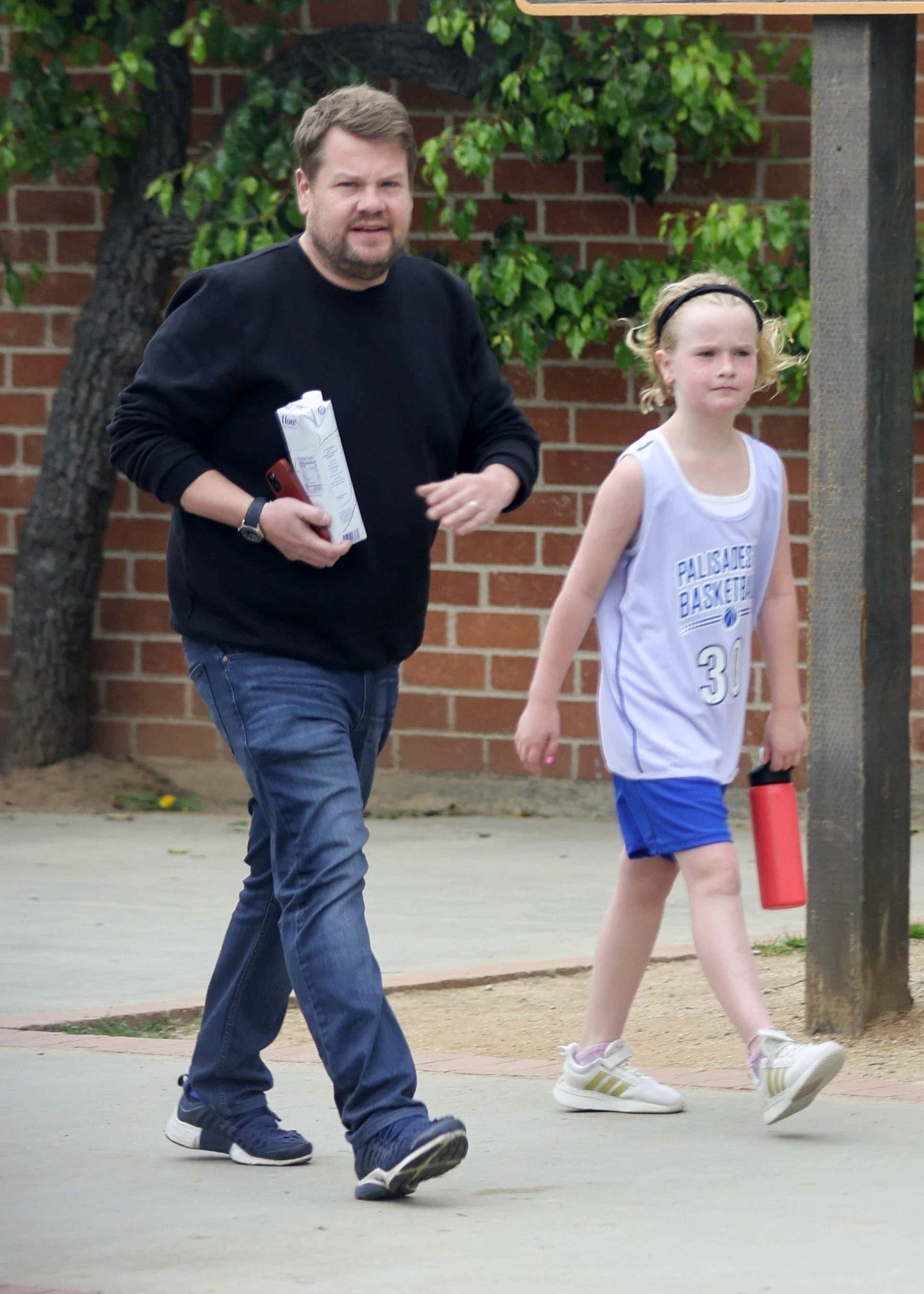 The comedian was photographed walking beside his eldest child as he picked her up from school (Backgrid)