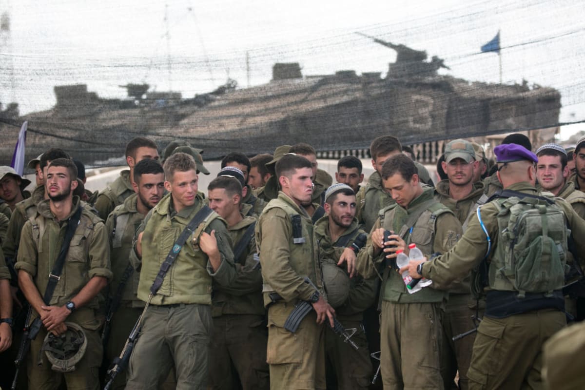 Israeli soldiers stand as they are waiting for a meeting with Israeli Minister of Defence Yoav Gallant on the Israeli border with thr Gaza Strip on October 19, 2023 in Sderot, Israel. (Photo by Amir Levy/Getty Images)