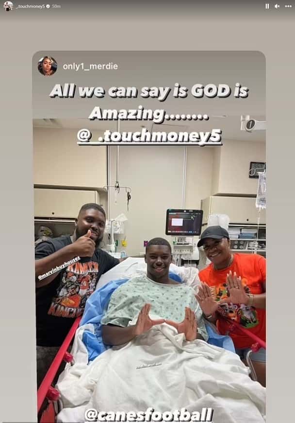 Kamren Kinchens posed for a photo while in hospital bed, shared by the Canes on social media (@_.touchmoney5/Instagram)