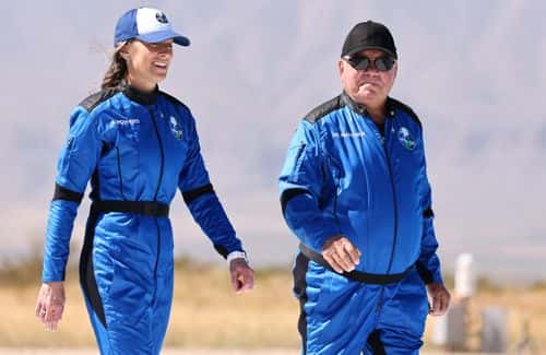Blue Origin vice president of mission and flight operations Audrey Powers (L) walks with Star Trek actor William Shatner to a media availability on the landing pad of Blue Origin’s New Shepard after they flew into space on October 13, 2021 near Van Horn, Texas. Shatner became the oldest person to fly into space on the ten minute flight. They flew aboard mission NS-18, the second human spaceflight for the company which is owned by Amazon founder Jeff Bezos. (Photo by Mario Tama/Getty Images)