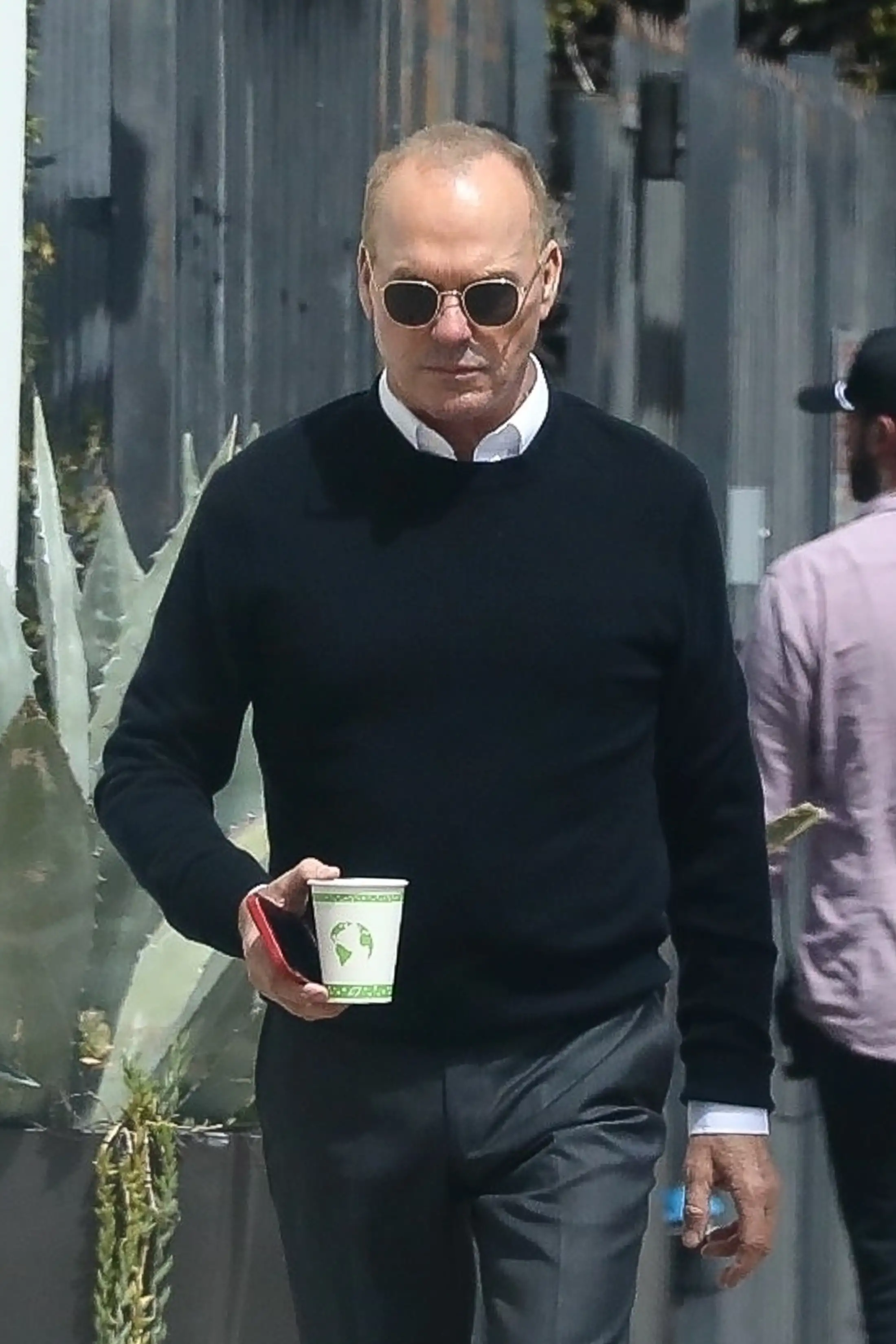Michael wore a navy blue sweater as he sported a pair of aviator shades while holding a cup of coffee (backgrid)