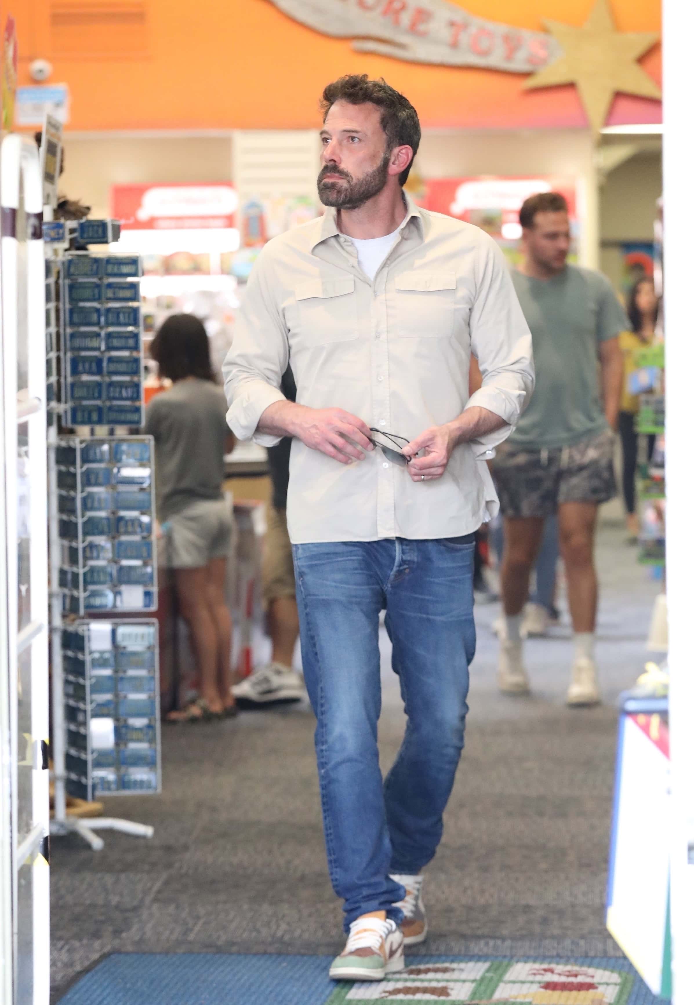 Affleck, for his part, opted for a more comfy ensemble featuring a light tan button-down shirt with a white shirt underneath. (Backgrid)