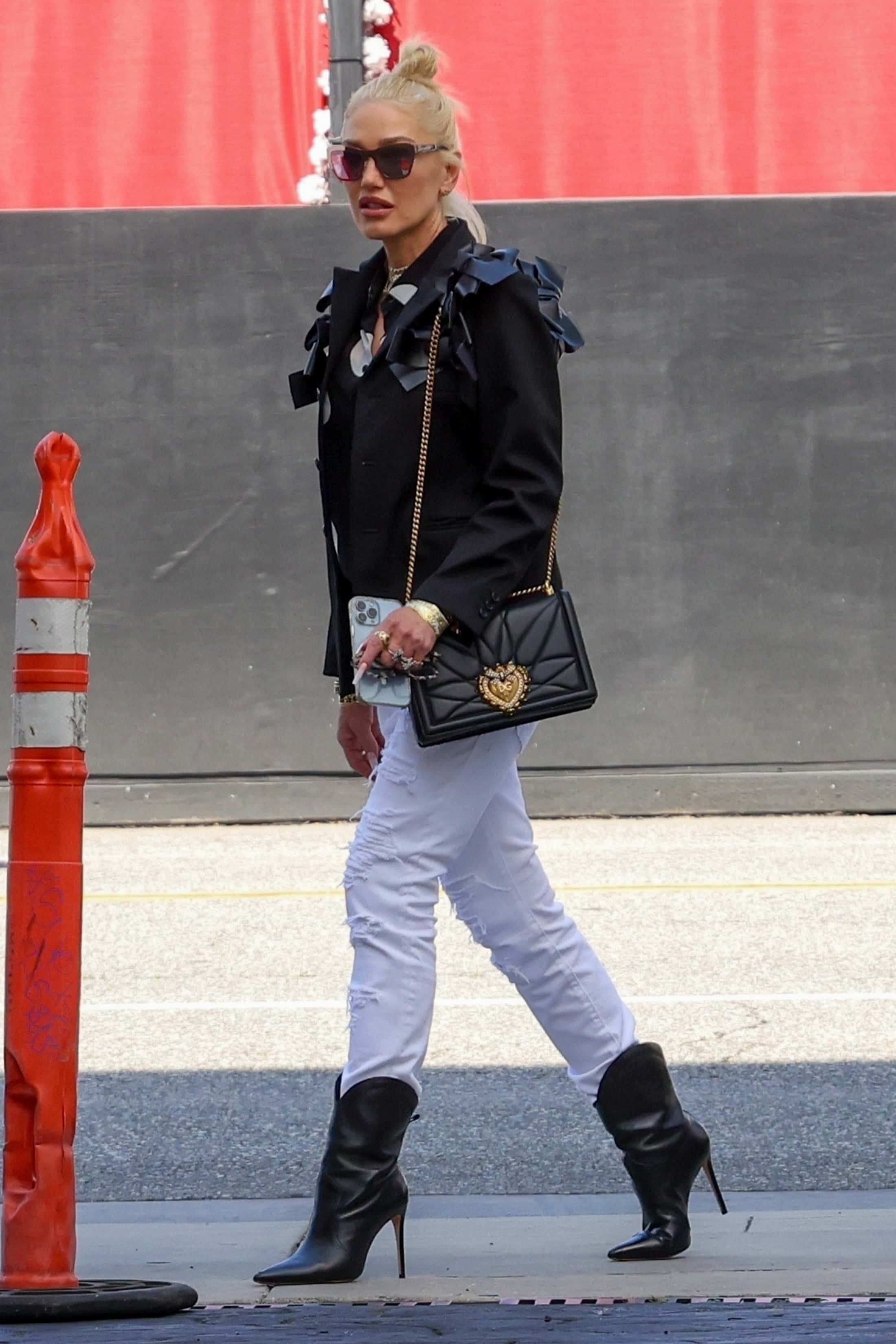 She also donned a black blazer that looked to be adorned with several ribbons around both shoulders and a pair of matching stiletto boots that came up the middle of her calves (Backgrid)