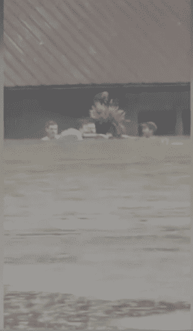 A man saving the lives of an elderly woman and others who were trapped in a house as the water kept rising on Thursday morning (Screenshot from CNN's videos)