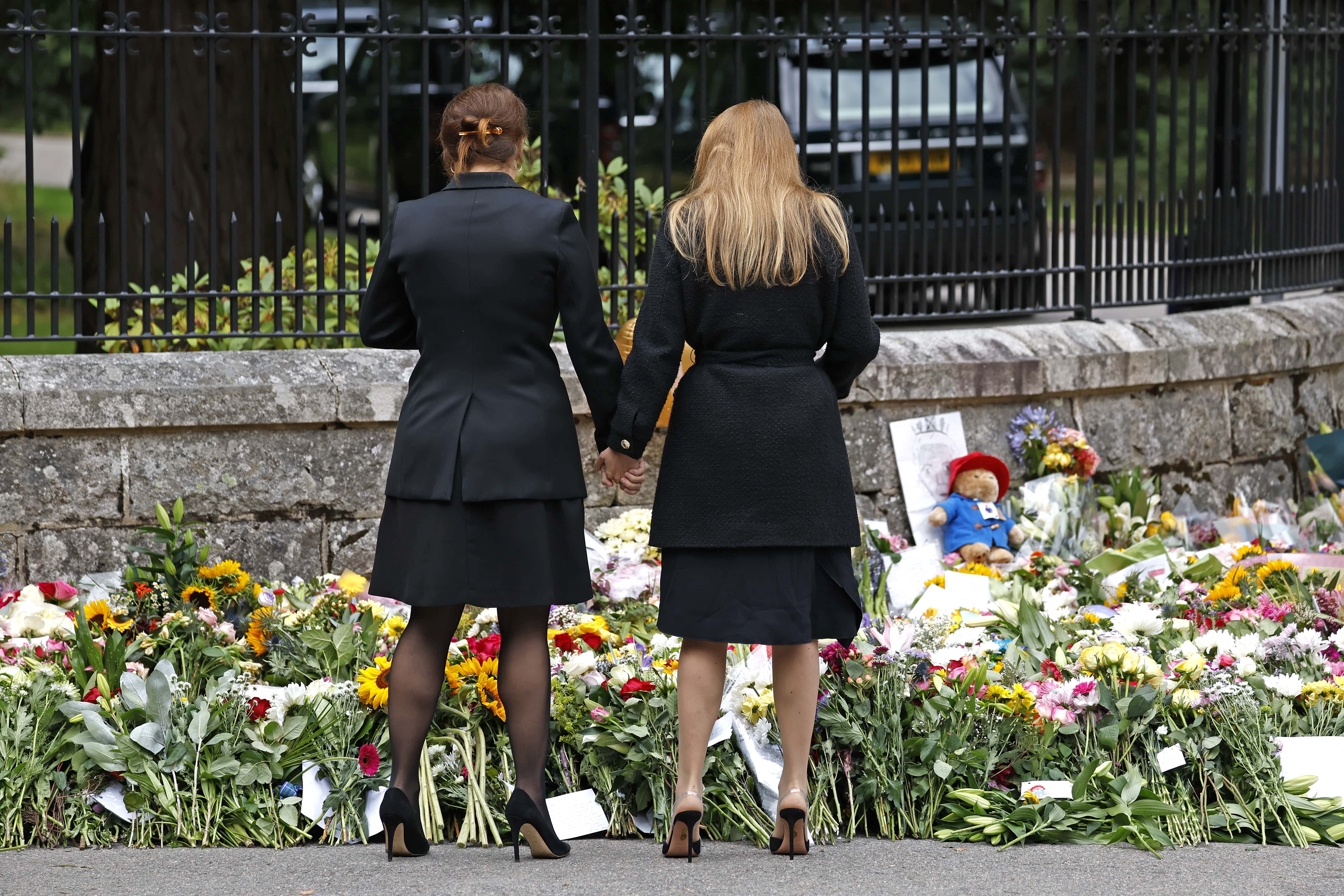Princess Eugenie of York and Princess Beatrice of York hold hands as they look at floral tributes outside Crathie Kirk church on September 10, 2022 in Crathie near Aberdeen, United Kingdom. Elizabeth Alexandra Mary Windsor was born in Bruton Street, Mayfair, London on 21 April 1926. She married Prince Philip in 1947 and acceded to the throne of the United Kingdom and Commonwealth on 6 February 1952 after the death of her Father, King George VI. Queen Elizabeth II died at Balmoral Castle in Scotland on September 8, 2022, and is succeeded by her eldest son, King Charles III.