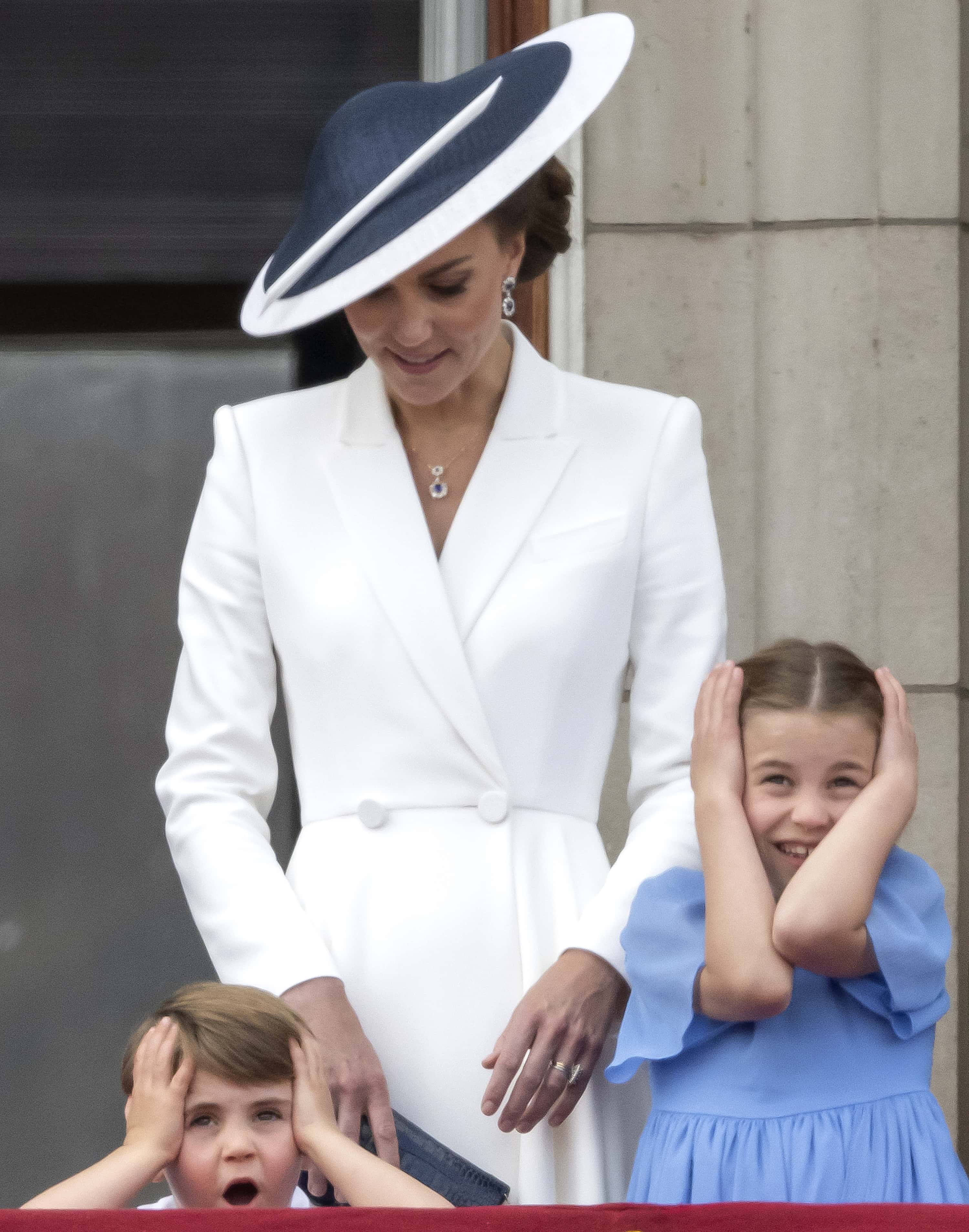 Prince Louis of Cambridge, Catherine, Duchess of Cambridge, and Princess Charlotte of Cambridge, on the balcony of Buckingham Palace watch the RAF flypast during the Trooping the Colour parade on June 02, 2022 in London, England. The Platinum Jubilee of Elizabeth II is being celebrated from June 2 to June 5, 2022, in the UK and Commonwealth to mark the 70th anniversary of the accession of Queen Elizabeth II on 6 February 1952.
