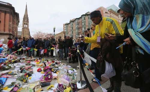2013 Boston Marathon volunteer Lydia (NO LAST NAME GIVEN) wears a marathon jacket while she visits a makeshift memorial for victims near the site of the Boston Marathon bombings a day after the second suspect was captured on April 20, 2013 in Boston, United States.  Lydia said, 